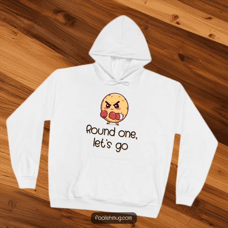 Funny hoodie showcasing a mischievous bagel character equipped with tiny boxing gloves, looking fiercely determined.