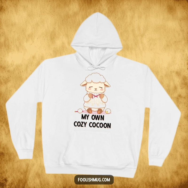 Funny sheep hoodie, depicting a tired sheep humorously knitting a sweater from its own fleece, ideal for cozy crafting sessions.
