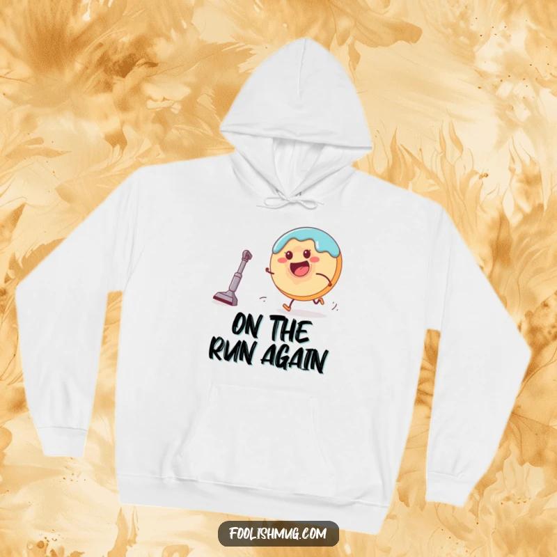 Funny donut character fleeing a small, hungry vacuum cleaner on a cozy hoodie, depicting a comical pursuit for warmth and laughs.