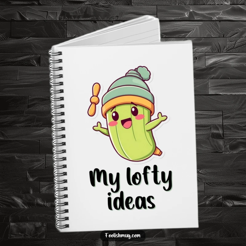 Funny pickle character wearing a propeller beanie, flying crookedly on the cover of a funny notebook.