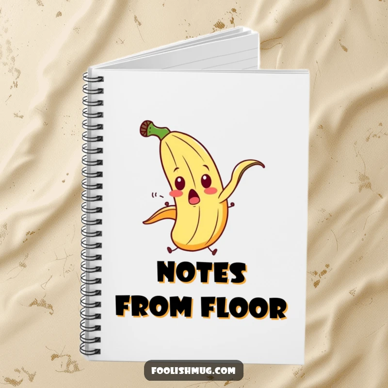 Funny banana peel character comically slipping on itself with exaggerated motion on a notebook, perfect for humorous note-taking.